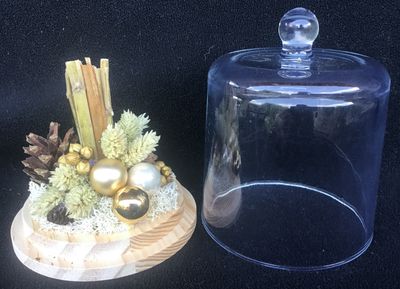 kerststukje met gras en kerstballen en stolpje