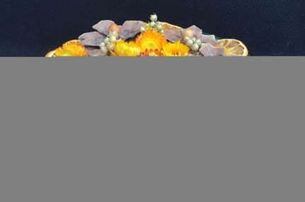Herfststukje in glazen schaal met droogbloemen, appelsien, ...
